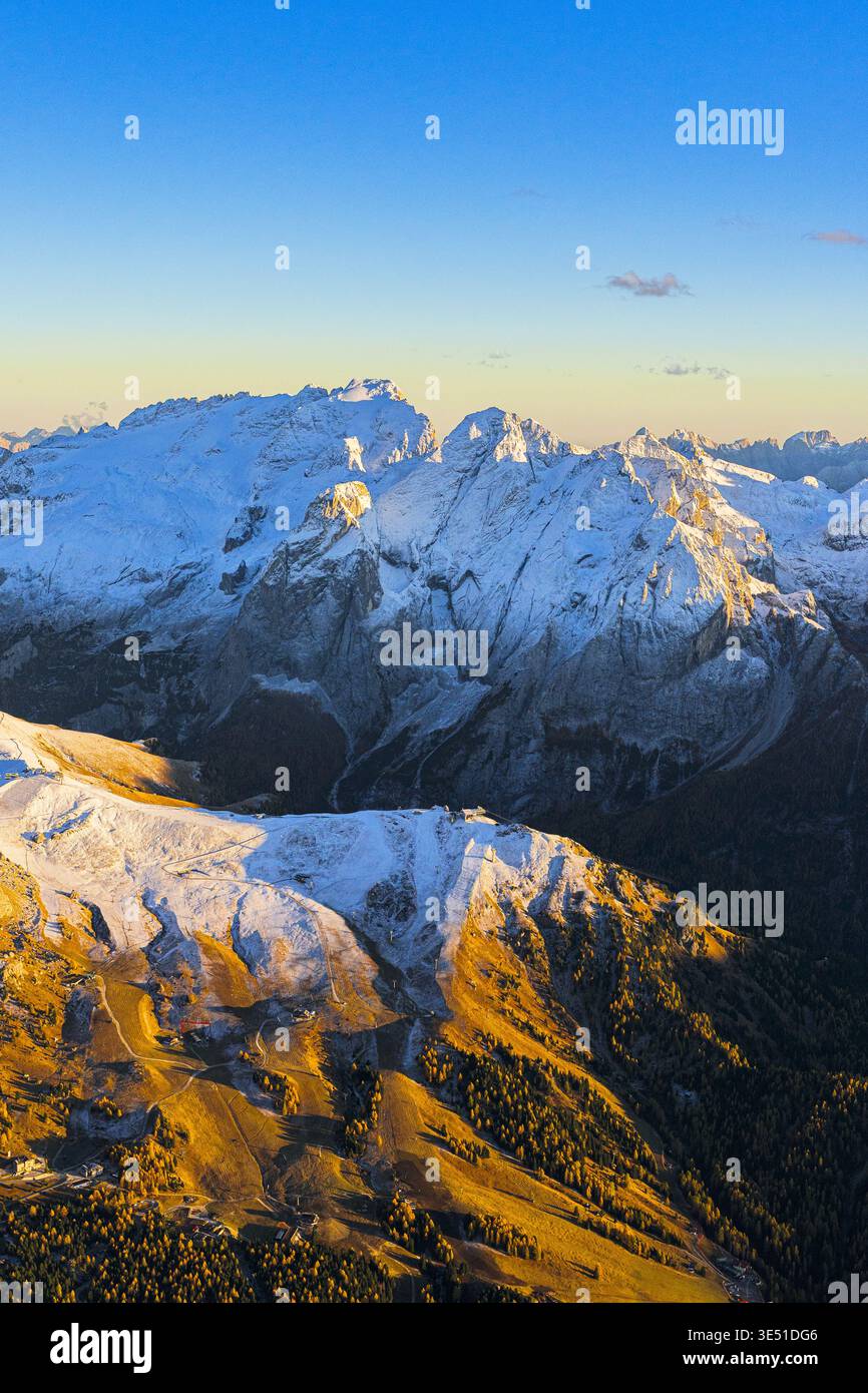 Vue aérienne des montagnes enneigées embrassées par le soleil doré, glacier Marmolada debout majestueusement contre le ciel Azur, Canazei, Marmolada, Ital Banque D'Images