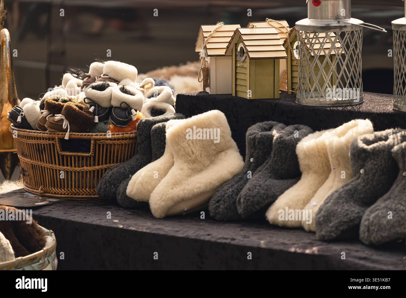 Chaussons en laine confortables et articles faits à la main exposés sur un stand de marché, présentant des textures chaudes, des matériaux doux et un charme artisanal rustique invitant. Banque D'Images