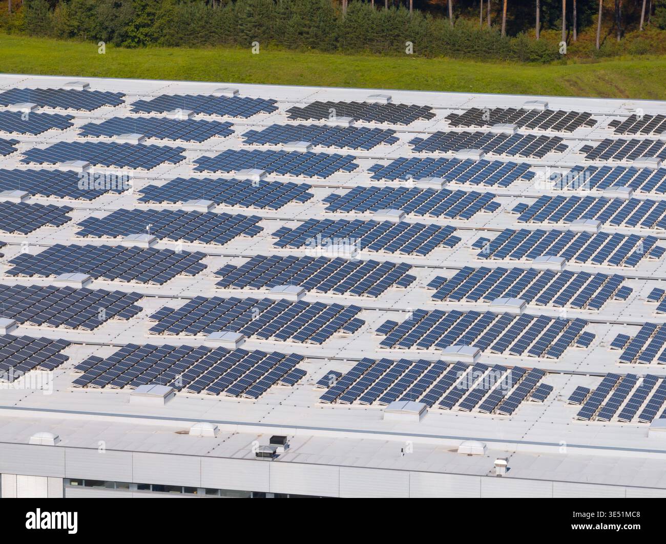 La vue aérienne montre des panneaux solaires installés sur un grand toit. Ces panneaux soutiennent la production d’énergie propre et contribuent à la durabilité. Banque D'Images