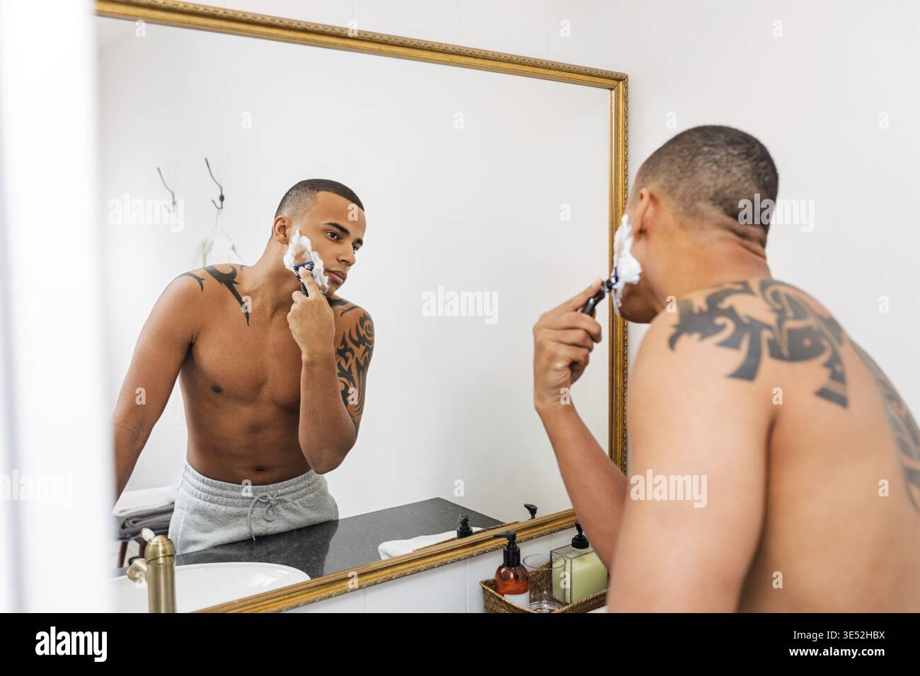 Homme debout devant un miroir rasage après une douche Banque D'Images