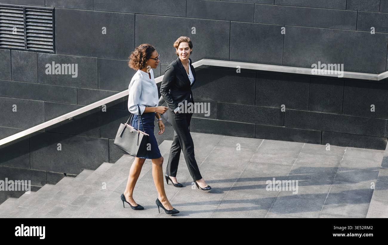 Deux femmes au pouvoir porter la marche à l'extérieur et de parler Banque D'Images