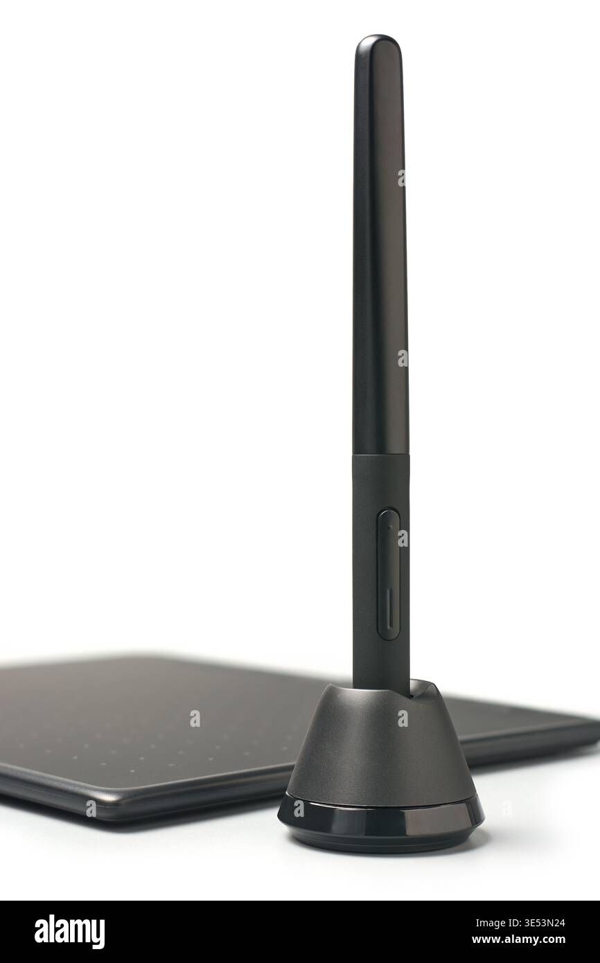 stylet numérique noir dans un support circulaire avec fond blanc isolé pour tablette graphique, périphérique de saisie à finition plastique mate, vue latérale Banque D'Images