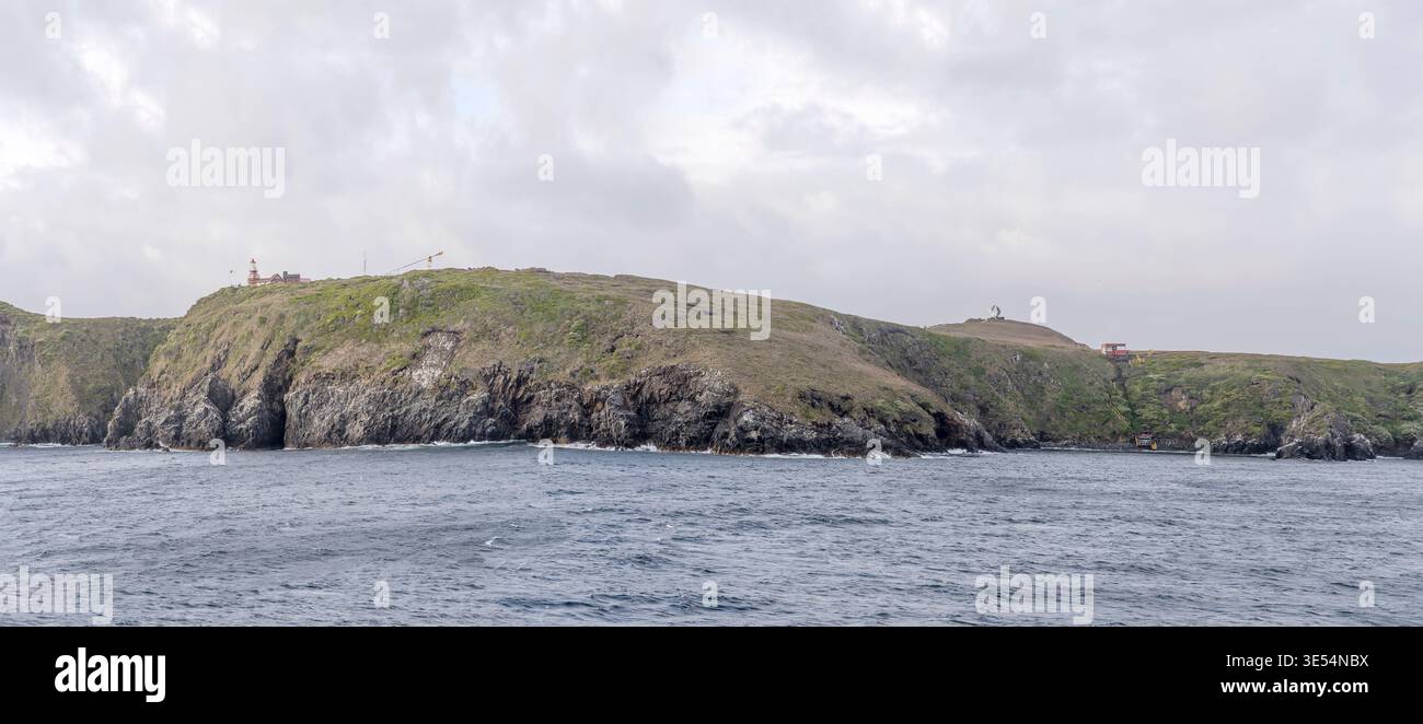 Paysage avec phare et lieu d'atterrissage sur les falaises abruptes de l'île Horn du nord-est, tourné dans une lumière nuageuse d'été brillante près de Horn Cap Banque D'Images