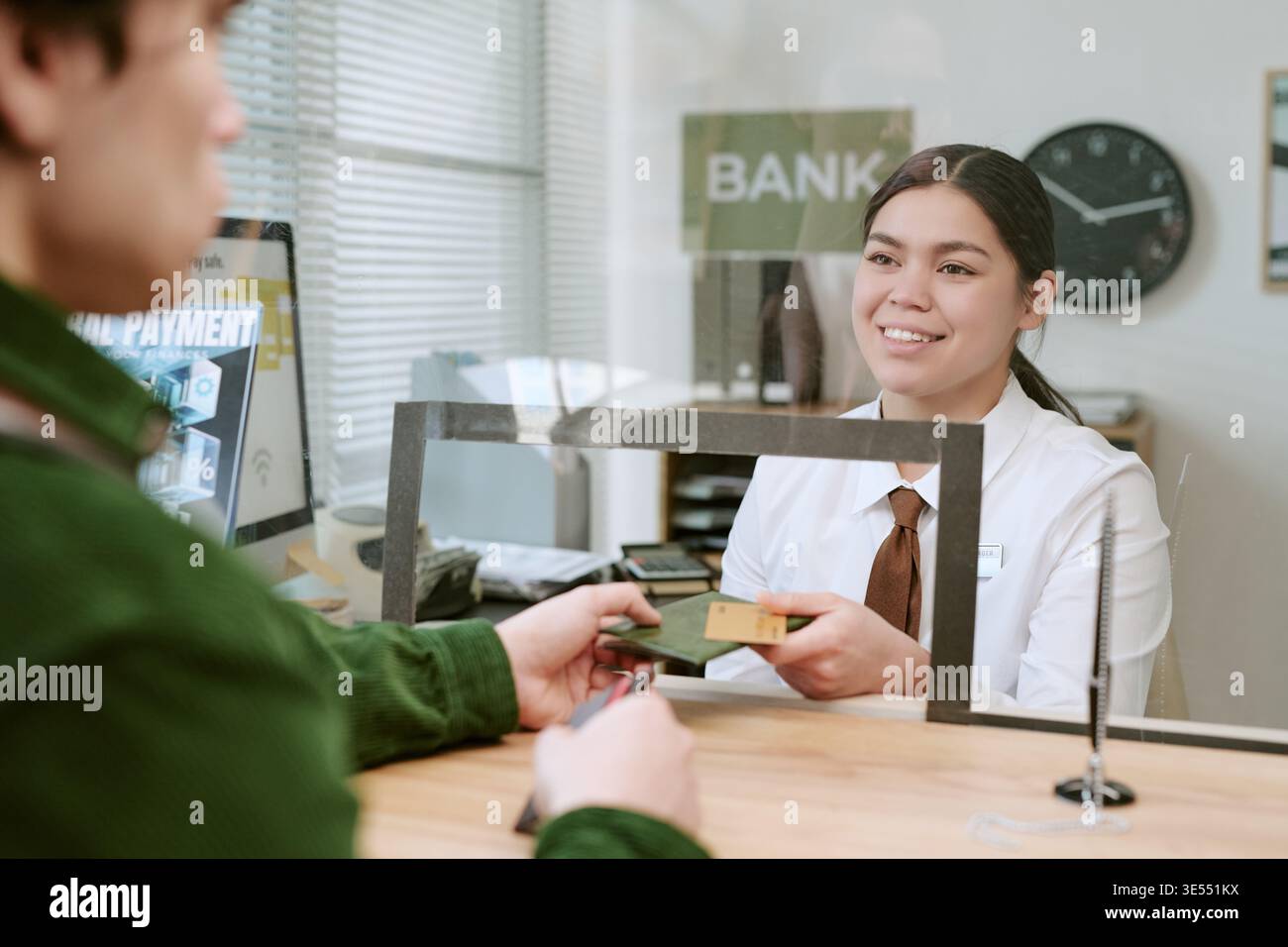 Femme assistant le client au guichet de l'agence bancaire Banque D'Images