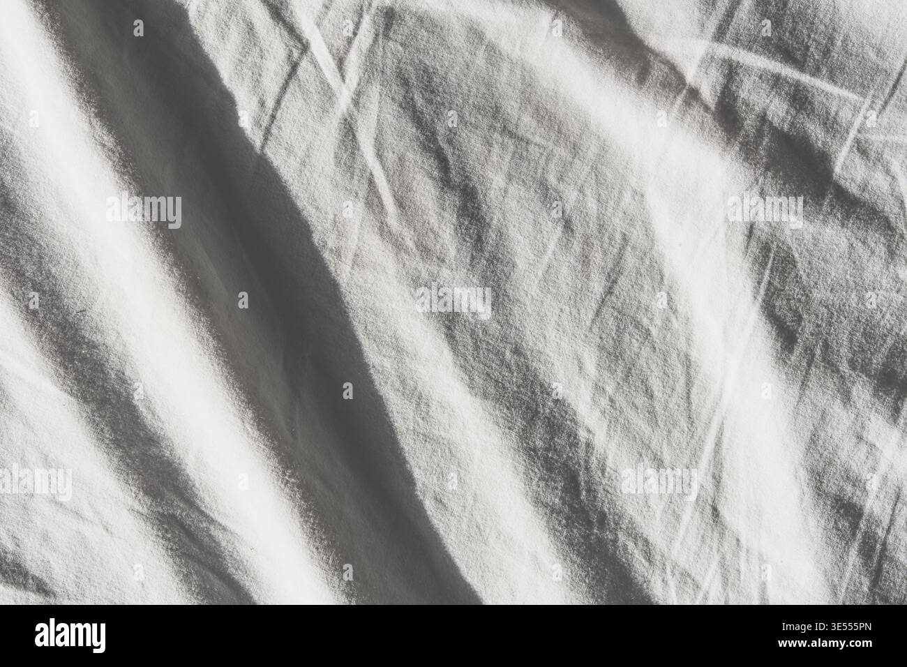 Surface de tissu blanc montrant des plis et des rides doux avec la lumière naturelle Banque D'Images