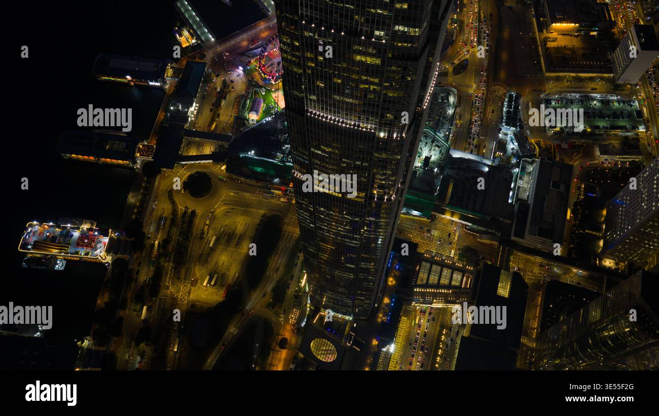Hong Kong - 13 février 2026 : vue aérienne du gratte-ciel illuminé de l'International Finance Centre et des jetées centrales des ferries la nuit. Banque D'Images