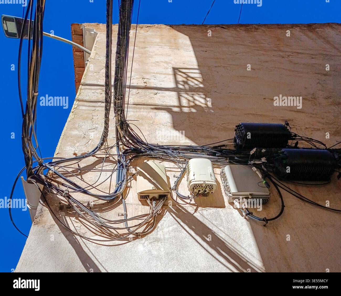 Câbles électriques et Internet désordonnés sur le mur du bâtiment Banque D'Images