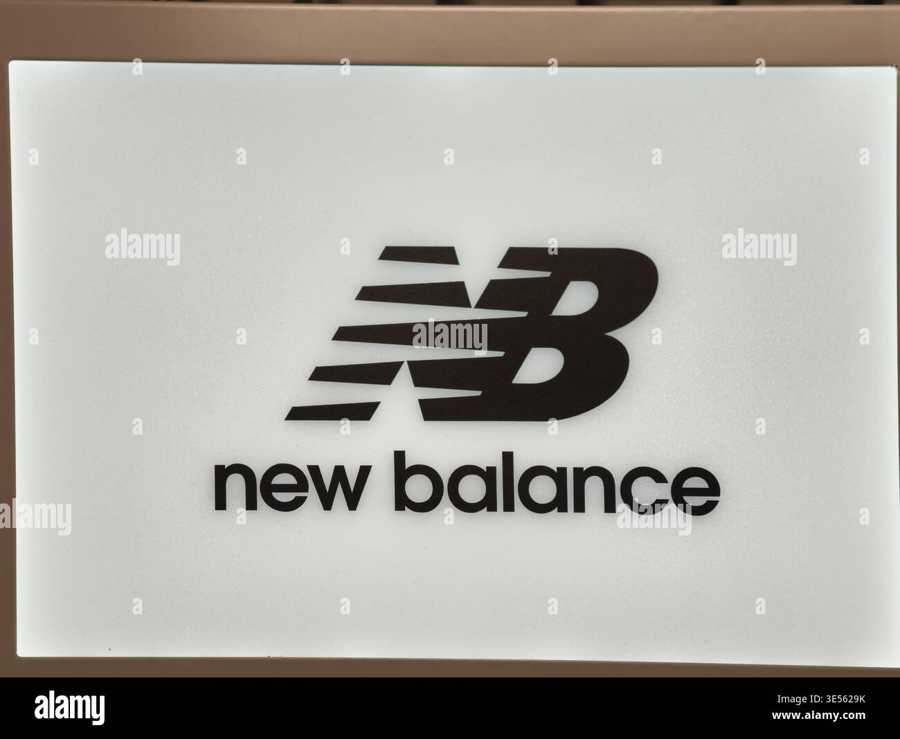 Prague, République tchèque - 1er avril 2026 : logo New Balance illuminé et monogramme NB sur un panneau beige d'affichage dans un magasin premium de Prague. Banque D'Images