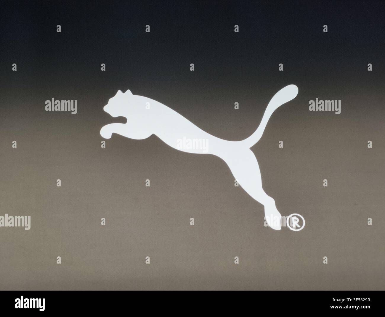 Prague, République tchèque - 31 mars 2026 : logo de chat sauteur Puma illuminé sur un panneau sombre au-dessus d'un volet de sécurité en treillis métallique dans un magasin de Prague. Banque D'Images
