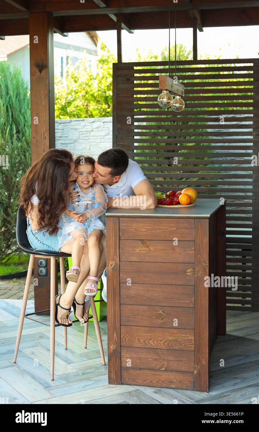 papa et maman embrassent leur fille Banque D'Images