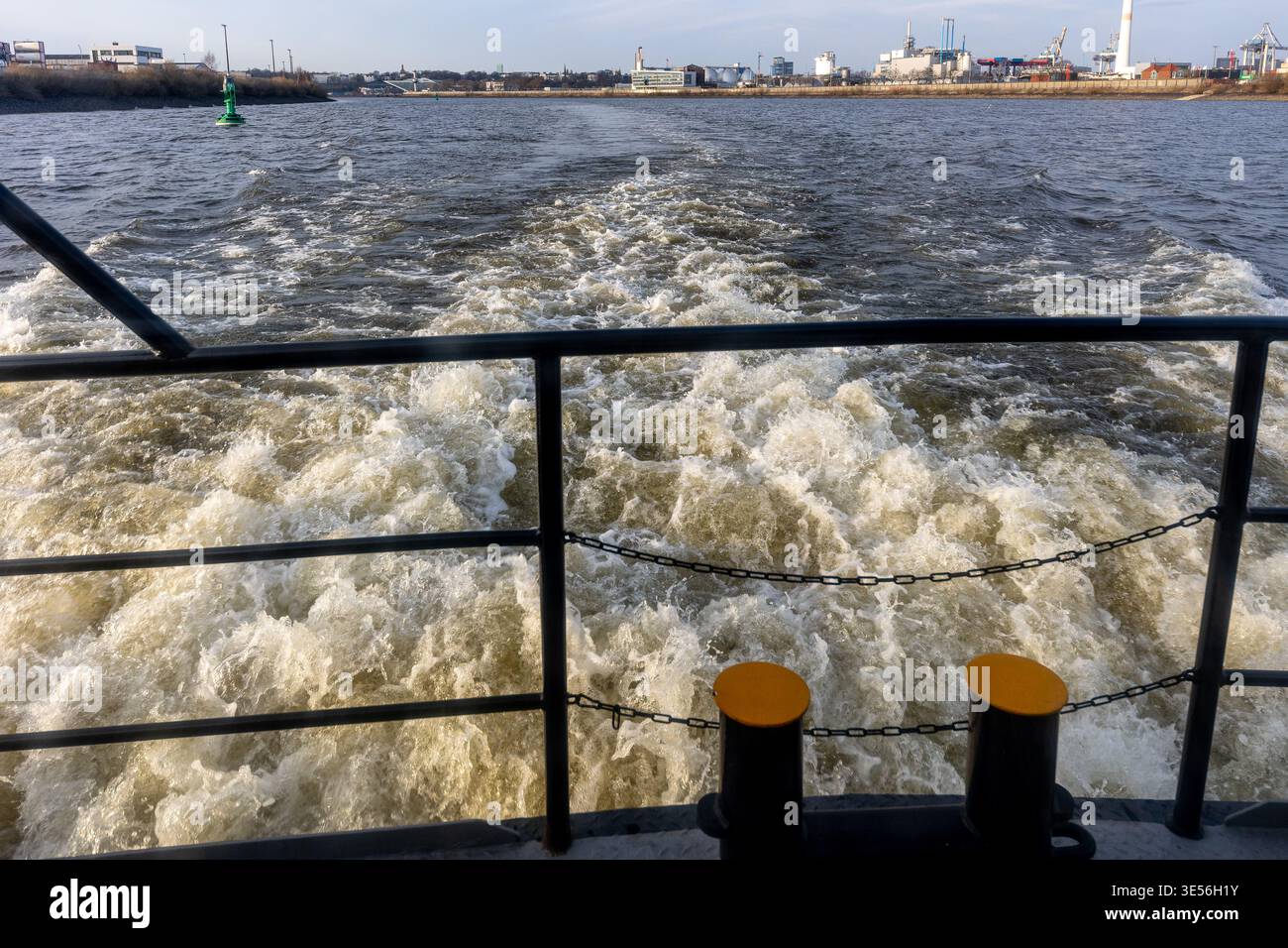 Un bateau se déplace à travers une rivière, provoquant le barbotage de l'eau autour de ses côtés. Des vagues et des ondulations se forment au passage du bateau. Le soleil brille sur le wa qui coule Banque D'Images