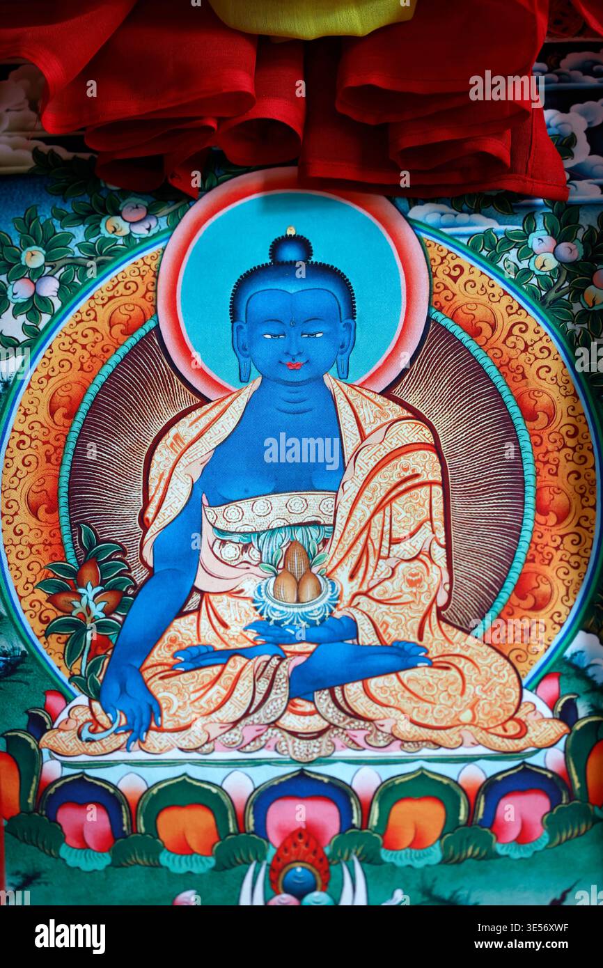 Vibrante peinture thangka tibétaine de Bouddha de médecine bleu assis en position de lotus avec des offrandes. Banque D'Images