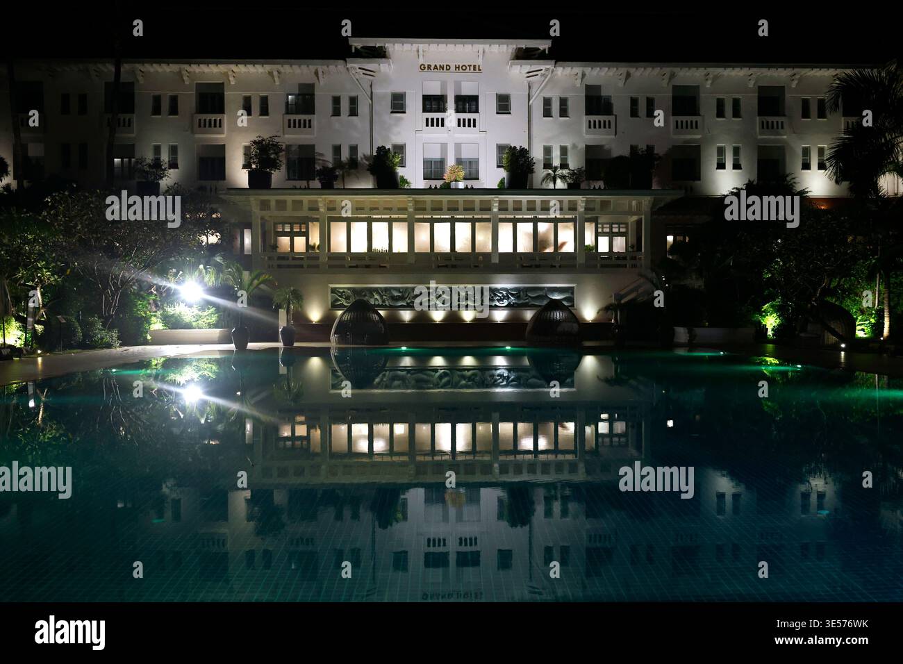 Expression authentique du style Art déco français des années 1930, le Raffles Grand Hotel d'Angkor est une destination riche en histoire. Piscine la nuit. Banque D'Images