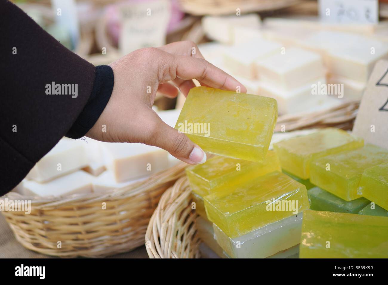 Main cueillant du savon dans un marché pendant la journée Banque D'Images