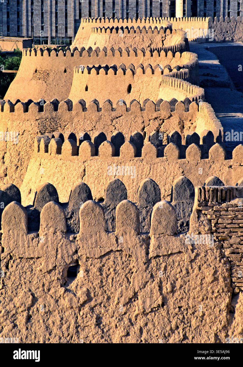 À Khiva, en Ouzbékistan, les vieux murs sont solides et montrent la riche histoire de la ville. Les gens marchent et explorent le site antique. Banque D'Images