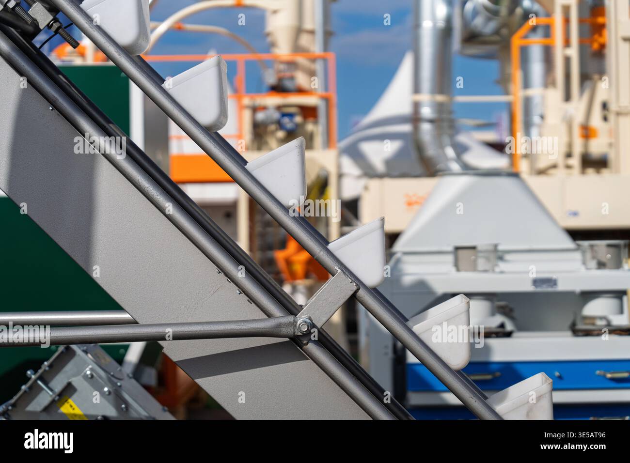 Système convoyeur élévateur à godets pour la manutention industrielle du grain et le transport de semences agricoles, gros plan de godets en plastique sur une courroie lors d'un traitement Banque D'Images