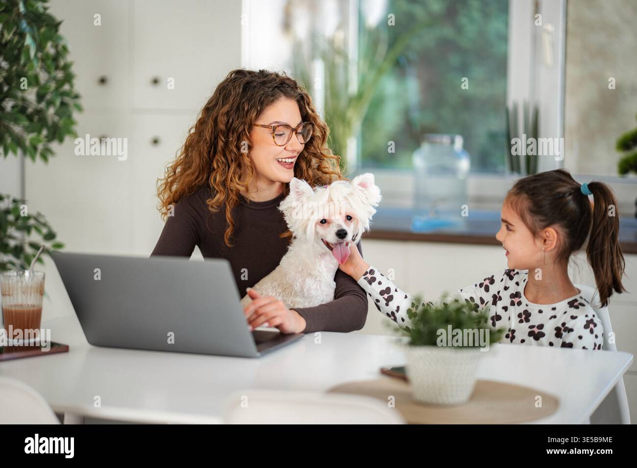 Mère, fille et chien travaillant et jouant ensemble Banque D'Images