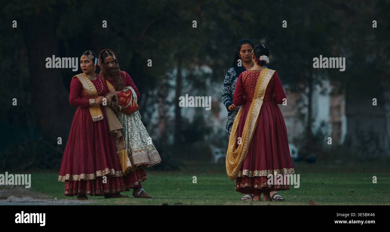 Trois femmes indiennes en robes traditionnelles colorées marchant ensemble à travers les jardins de Red Fort Banque D'Images