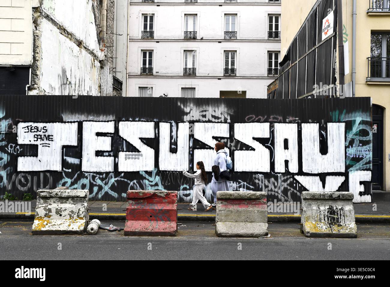 'Jesus Save' vaporisez peinture et affiches sur un chantier de Montmartre - Paris - France Banque D'Images