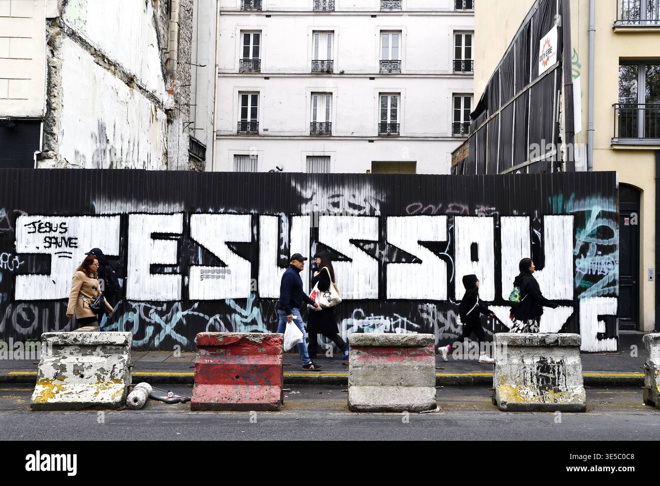'Jesus Save' vaporisez peinture et affiches sur un chantier de Montmartre - Paris - France Banque D'Images