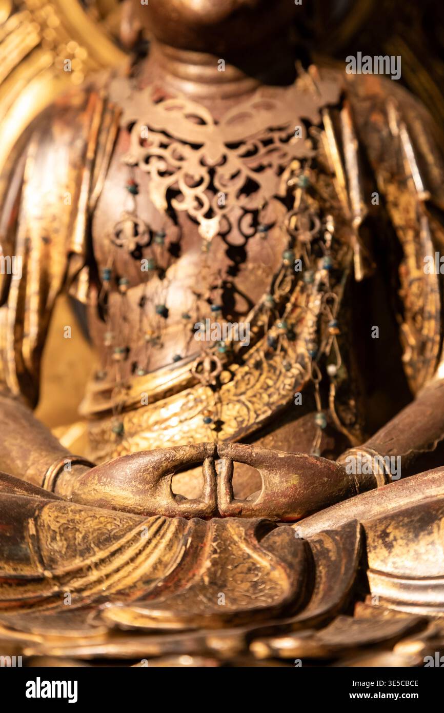 Gros plan d'une statue de Bouddha dorée montrant des mains détaillées dans le mudra de méditation, symbolisant la paix, la spiritualité et l'illumination avec ornam complexe Banque D'Images