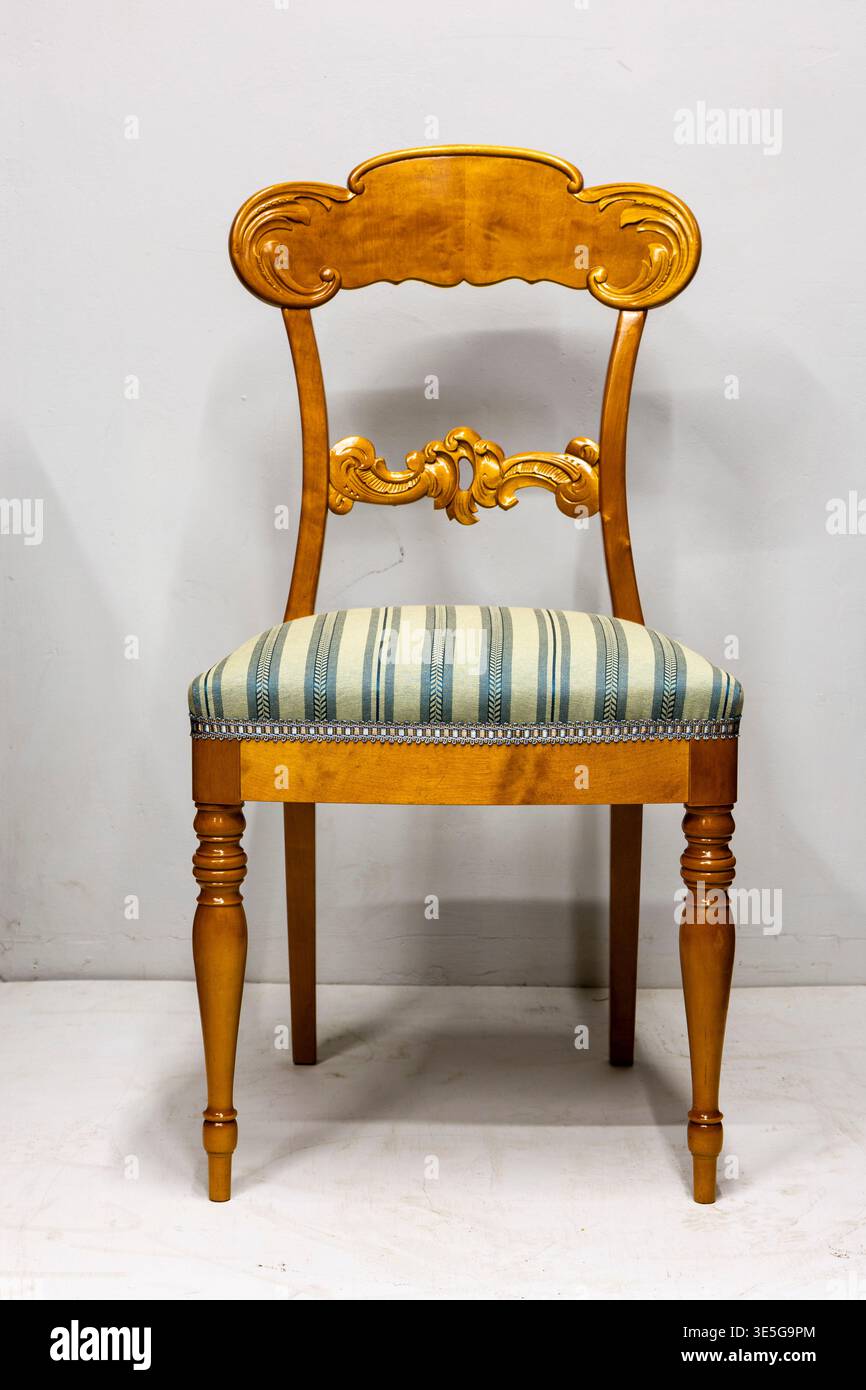 Élégante chaise vintage en bois avec un coussin rayé parfait pour la décoration classique de la maison Banque D'Images