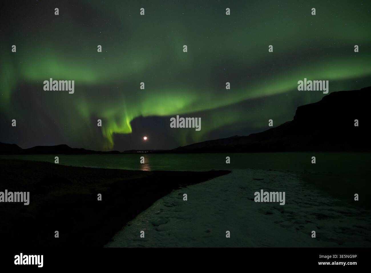 Aurora borealis au-dessus du fjord lunaire en croissant d'Islande Banque D'Images
