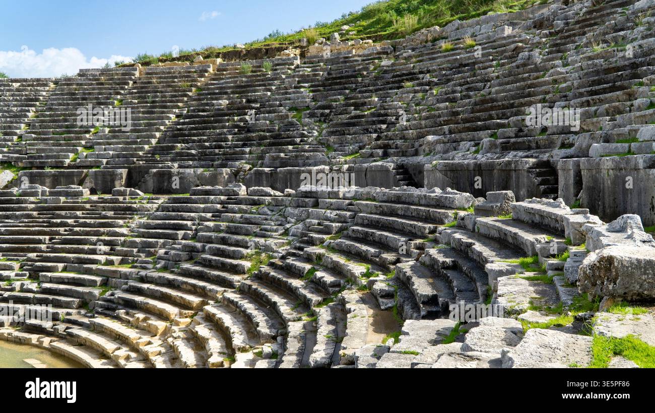 Sièges en pierre antique du théâtre hellénistique de la ville antique de Letoon, montrant des rangées courbes, des textures altérées et une structure en terrasses près de la ville de X. Banque D'Images