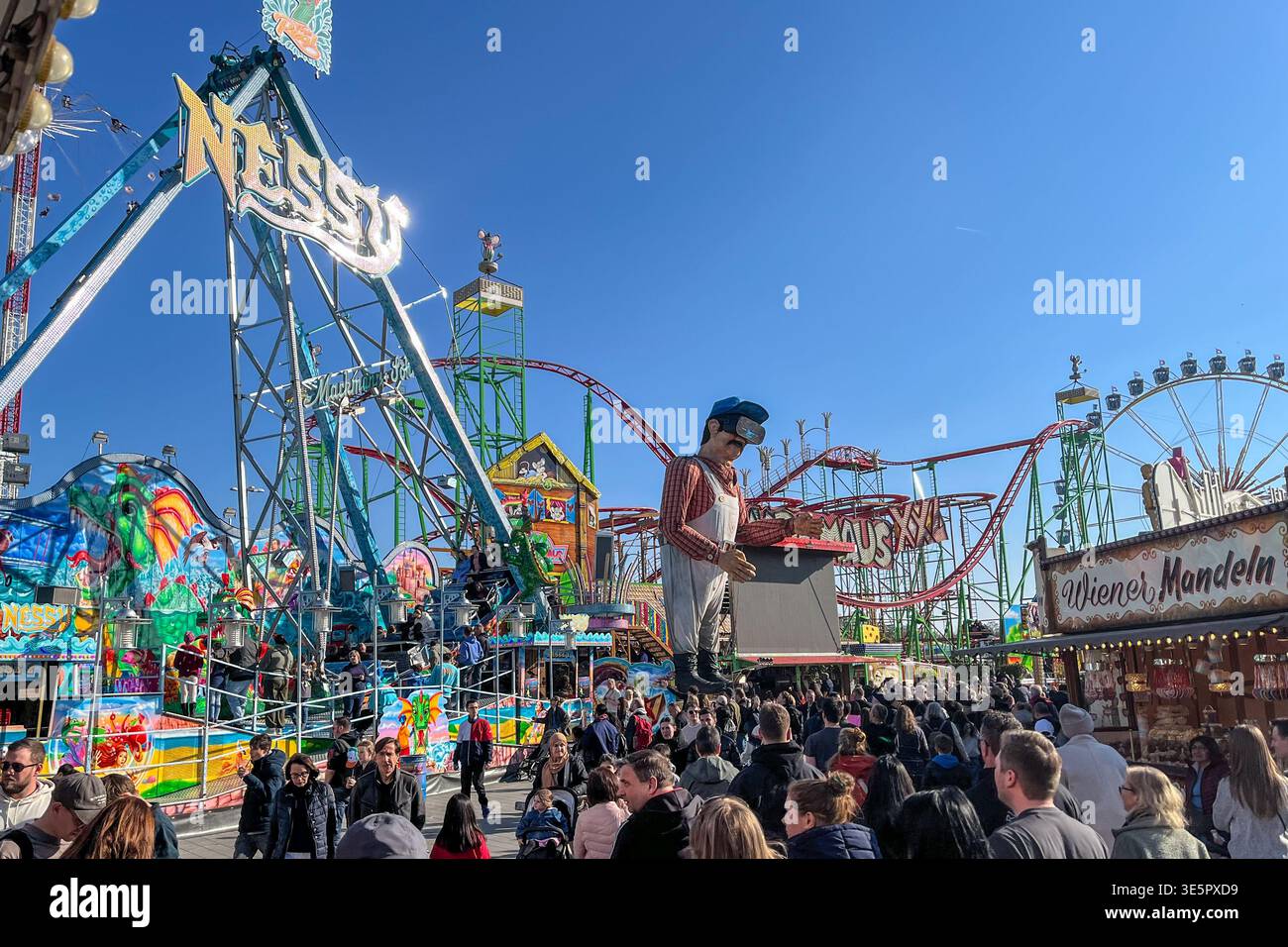 Hambourg, Allemagne - 22 mars 2026 : manèges et stands de nourriture à la grande foire Hamburger Dom. Schiffschaukel, Rollercoaster et Ferris Wheel. Larg Banque D'Images