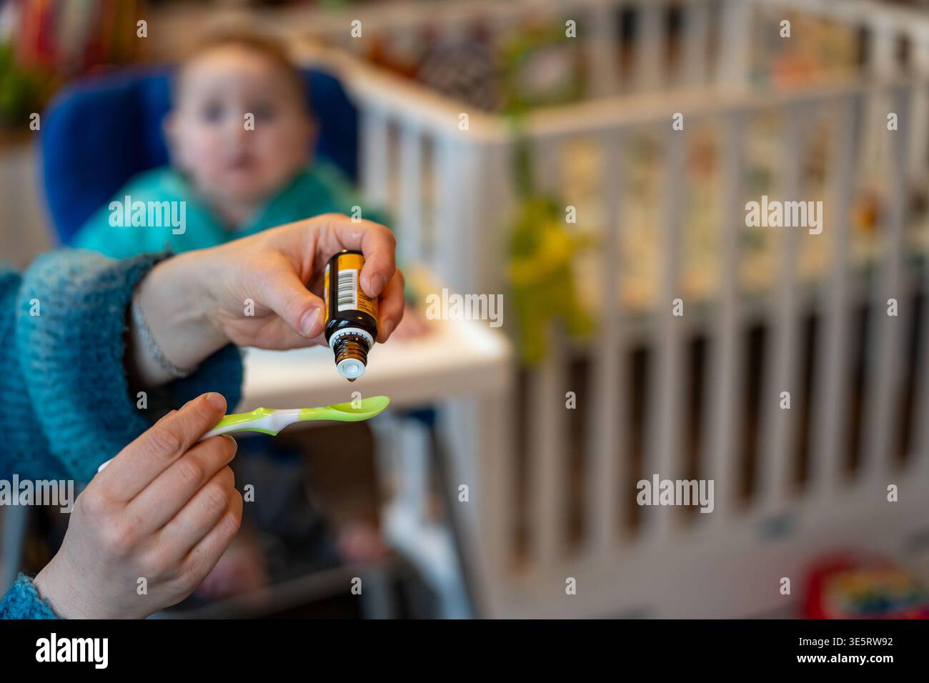 Supplémentation en vitamine d pour bébé avec des gouttes liquides sur cuillère donnée par les parents Banque D'Images