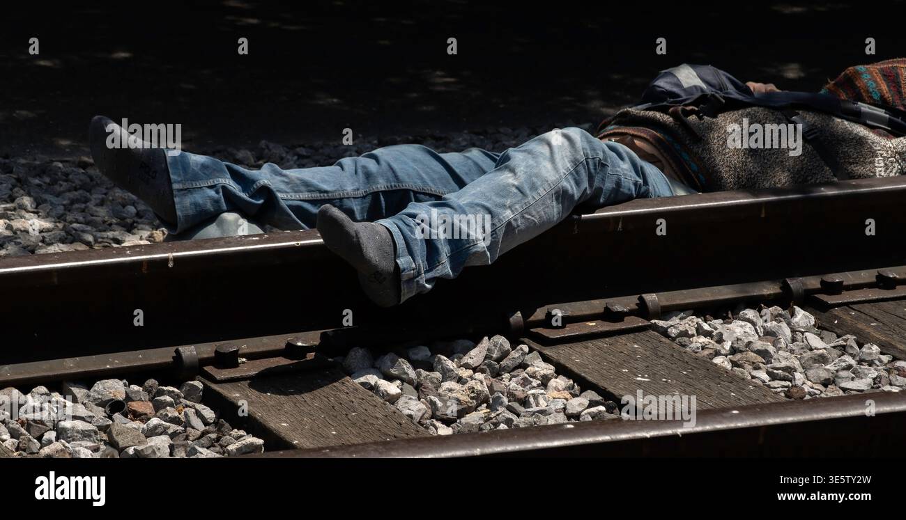 Homme avec des jambes sur les voies ferrées Banque D'Images