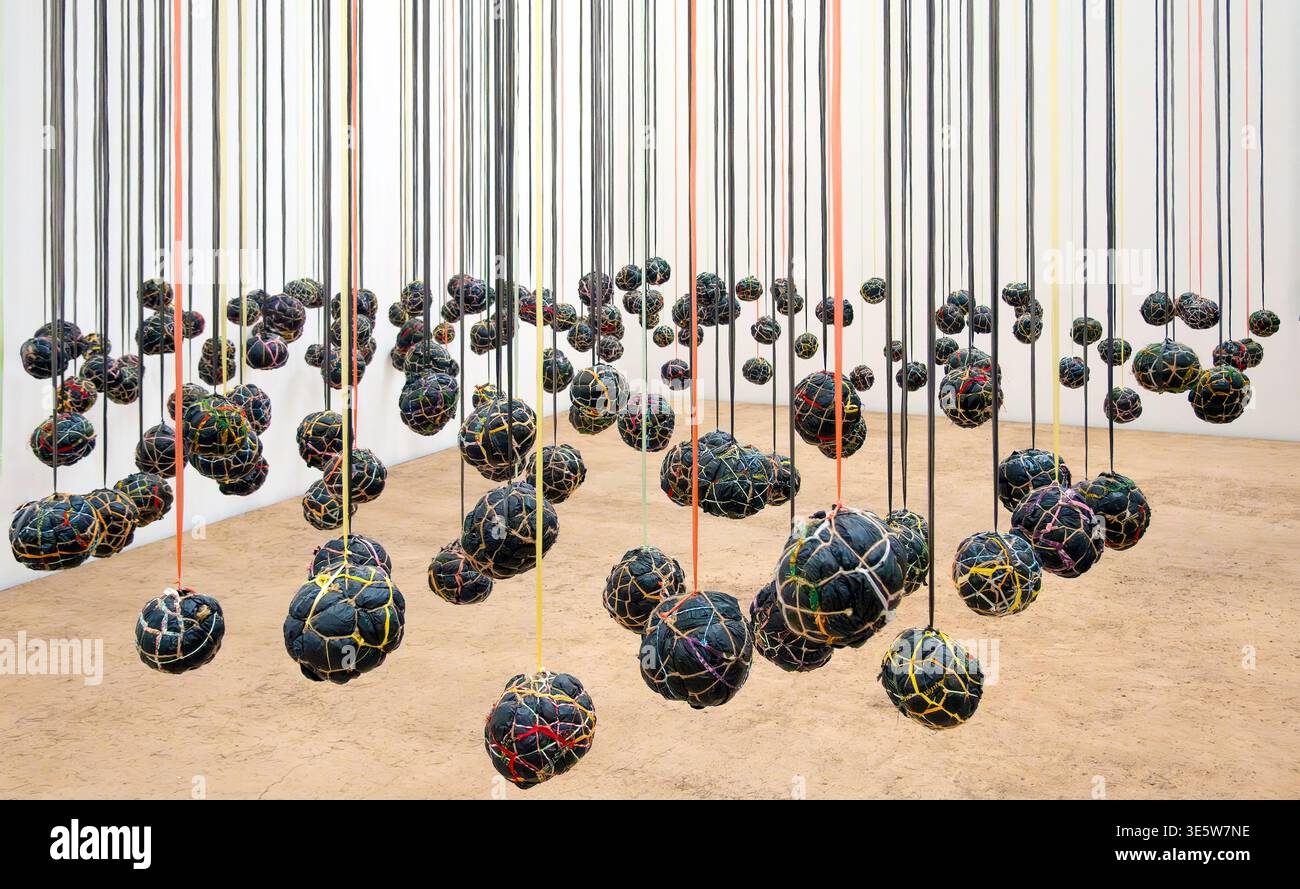 Installation artistique suspendue de Playtime par l'artiste kenyan Wangechi Mutu utilisant des ballons de football fabriqués à partir de sacs en plastique, couvertures et corde Banque D'Images