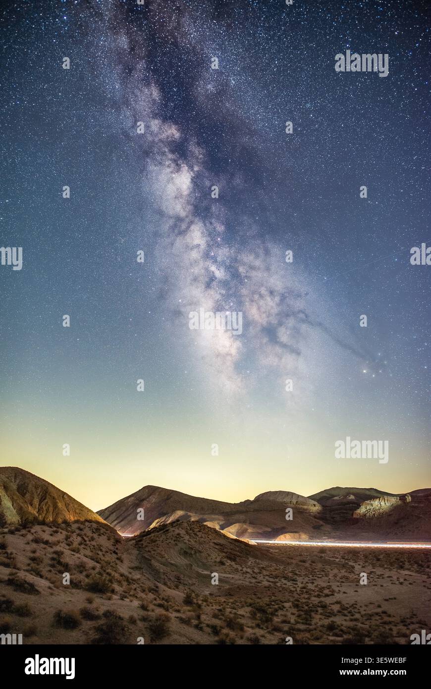 Galaxie de la voie lactée s'élevant au-dessus des montagnes du désert sous un ciel nocturne clair avec des étoiles visibles et des détails cosmiques. Banque D'Images