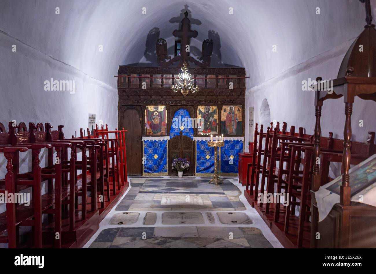 Intérieur d'une église orthodoxe avec bougies, autel et icônes religieuses. Composition symétrique, atmosphère spirituelle, architecture historique. Banque D'Images