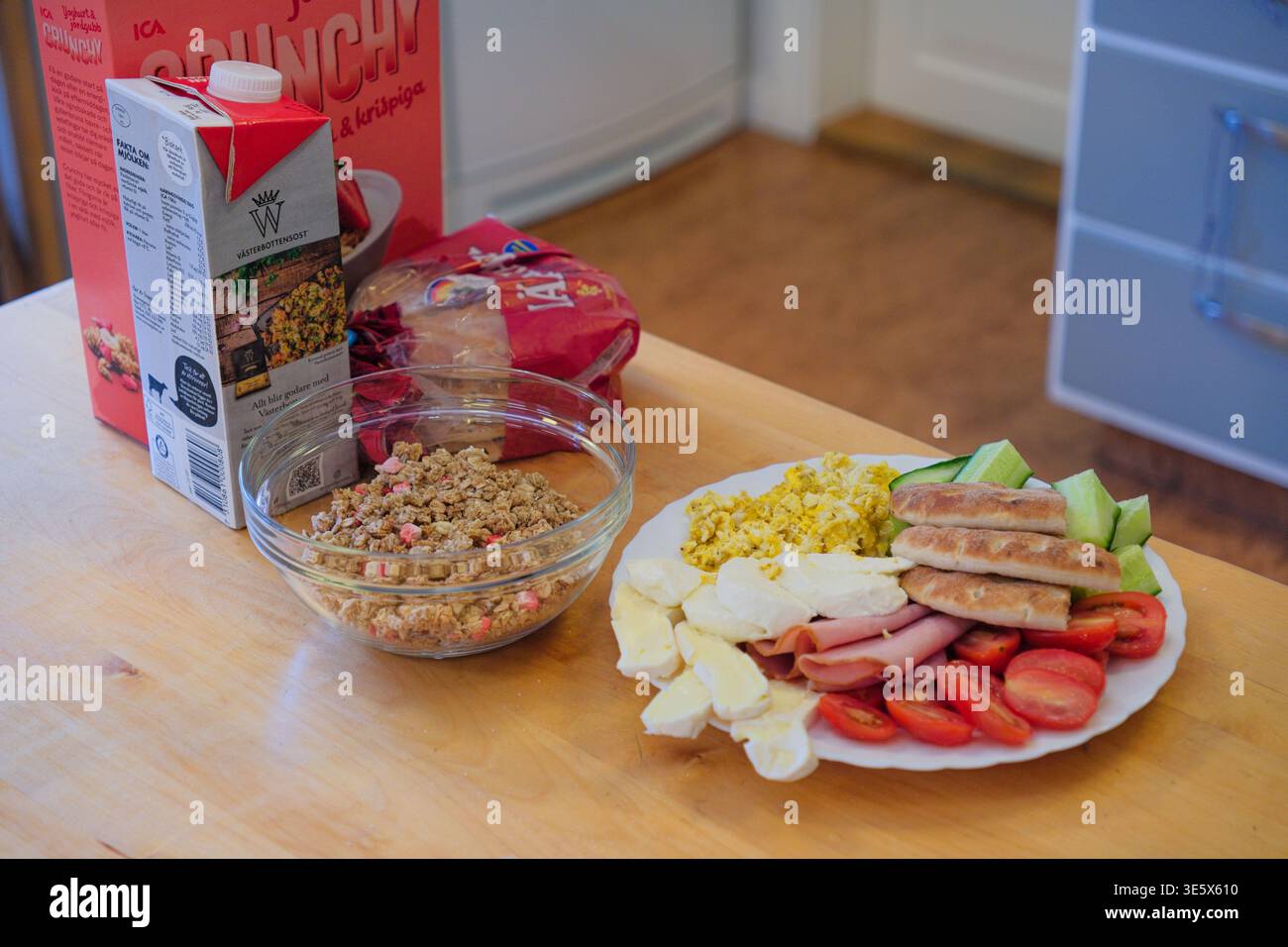 Jakkvik, Suède - 28 juillet 2024 : un copieux petit déjeuner incluant du lait de céréales ICA Crunchy et une assiette variée de protéines et de légumes dans un Swedis Banque D'Images