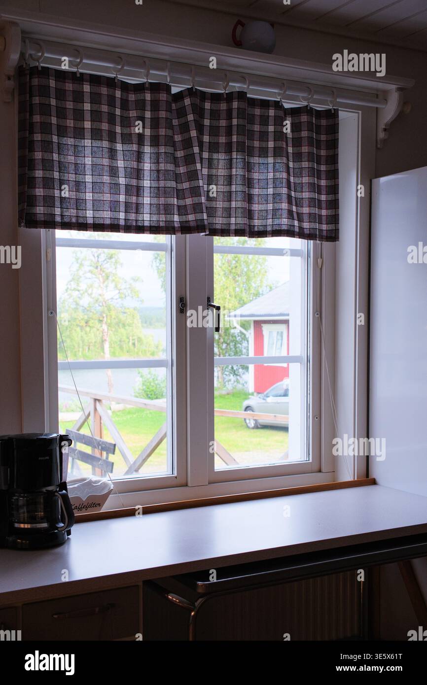 Jakkvik, Suède - 28 juillet 2024 : une vue paisible de l'intérieur de l'hébergement STF Jakkvik montrant les collines herbeuses environnantes et les bâtiments ruraux th Banque D'Images