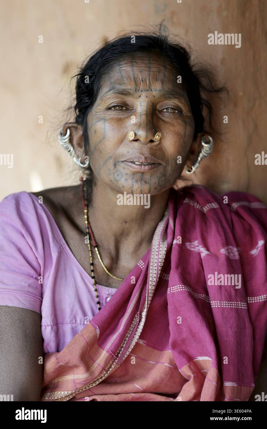 Odisha, Inde - 26 mars 2026 : vue du visage d'une femme indigène orné de tatouages traditionnels et de lobes d'oreilles étirés, encadrée par un simple sar rose Banque D'Images