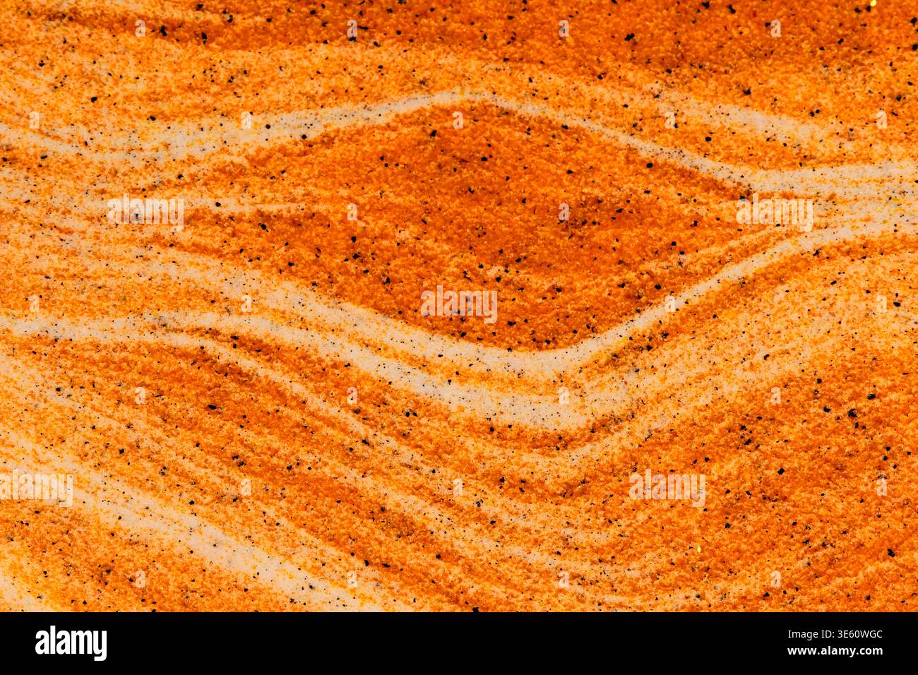 Une formation en forme d'oeil dans le sable orange entouré de couches blanches ondulées. Composition d'art de sable symétrique unique Banque D'Images