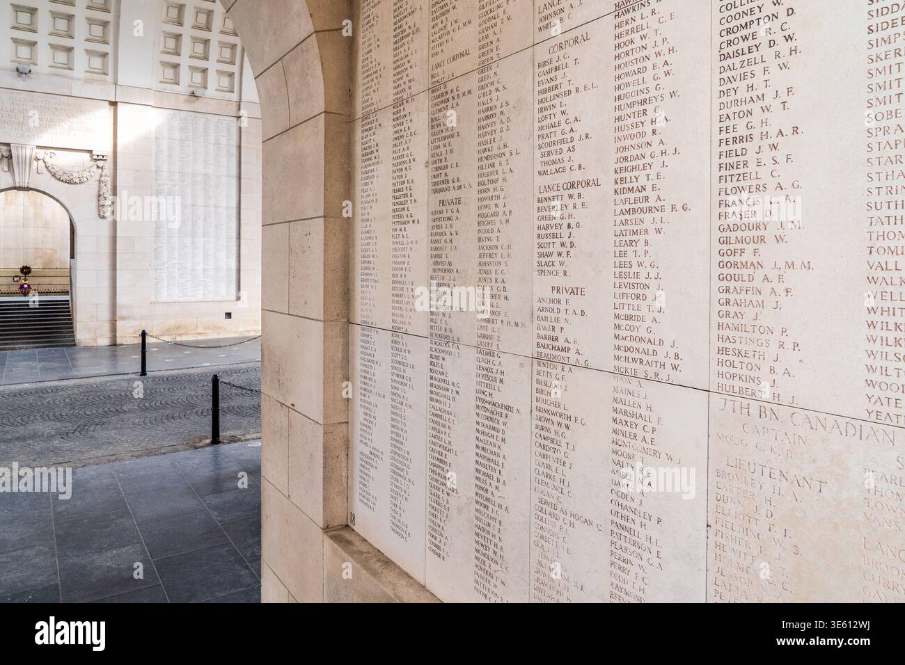 Un gros plan incliné montre les noms des tombés du 7e Bataillon canadien gravés sur la pierre blanche de la porte Menin à Ypres. Lumière naturelle Banque D'Images