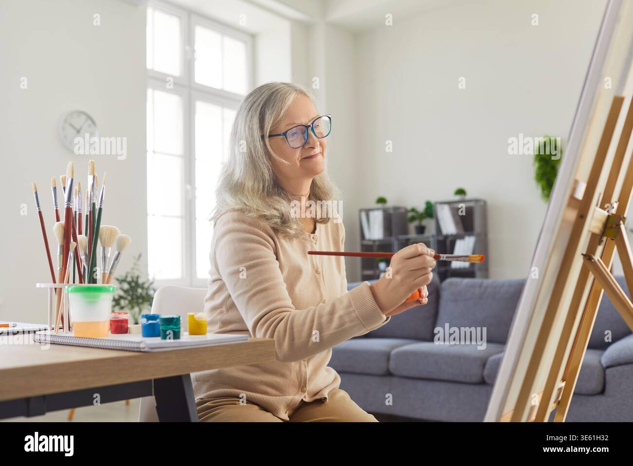 Femme âgée créative peignant l'image avec des aquarelles, en essayant de faire un chef-d'œuvre Banque D'Images