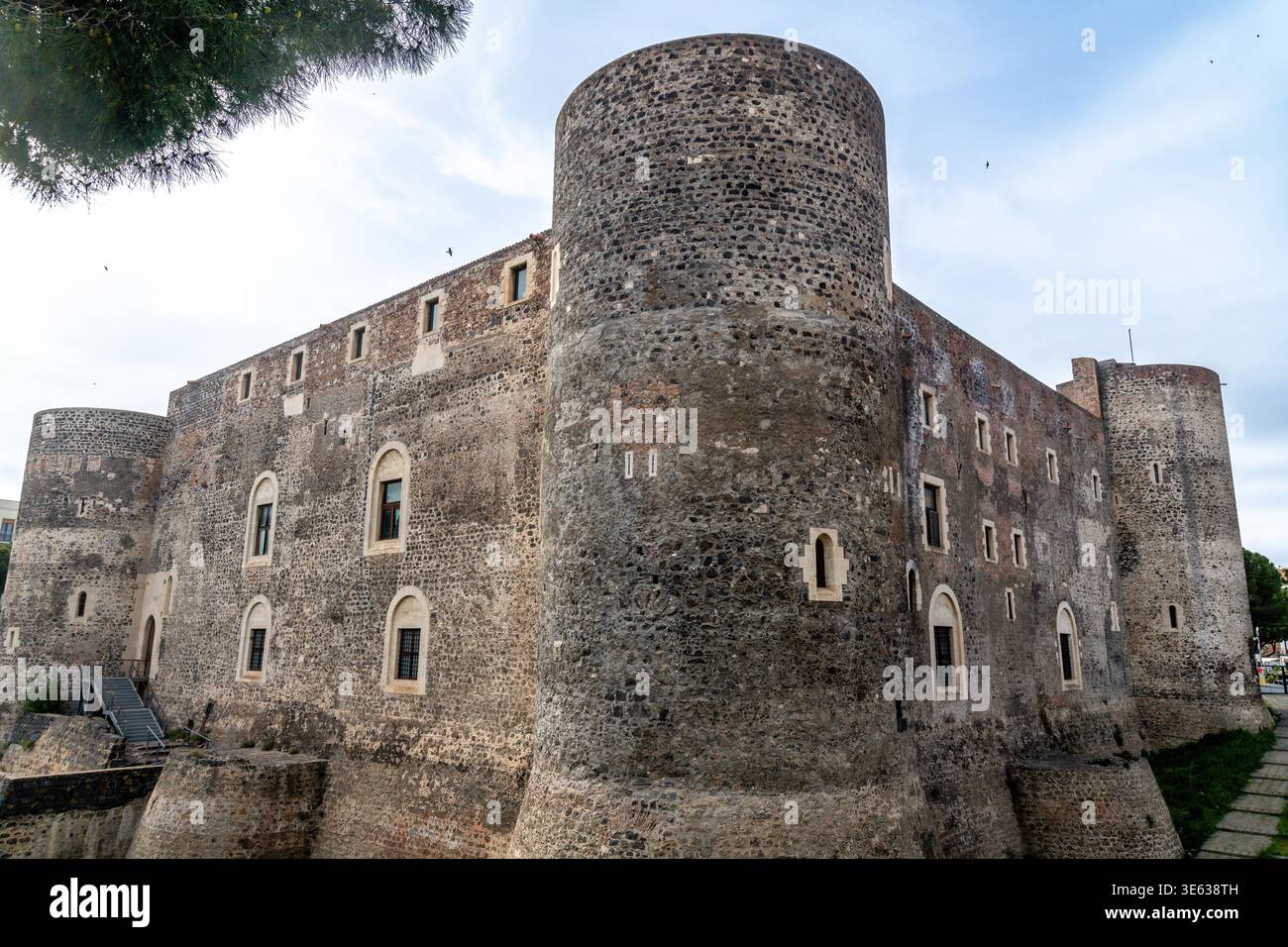 Vue large du Castello Ursino à Catane montrant de grandes tours cylindriques, des murs en pierre, des fenêtres cintrées et une partie des douves environnantes. Banque D'Images