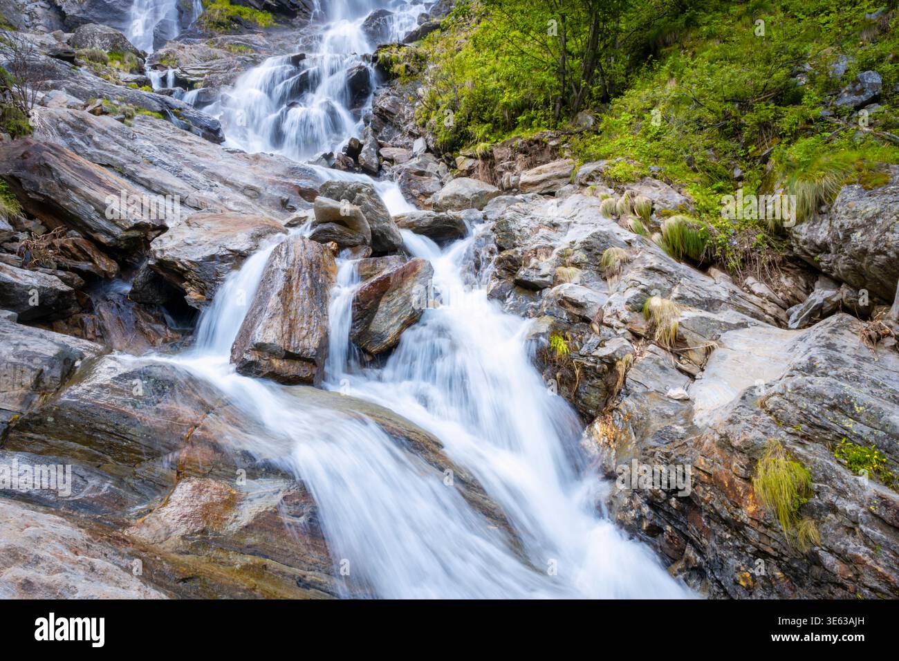 Cascade alpine avec mouvement flou, près du village d'Alagna (région du Piémont, Italie du Nord) sur les pentes du massif du Monte Rosa. Banque D'Images