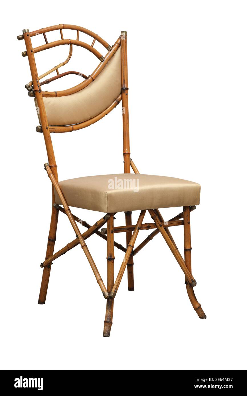 Cette élégante chaise en bambou dispose d'un dossier unique et d'un coussin beige confortable, idéal pour améliorer toute ambiance d'événement intérieur ou extérieur. Banque D'Images