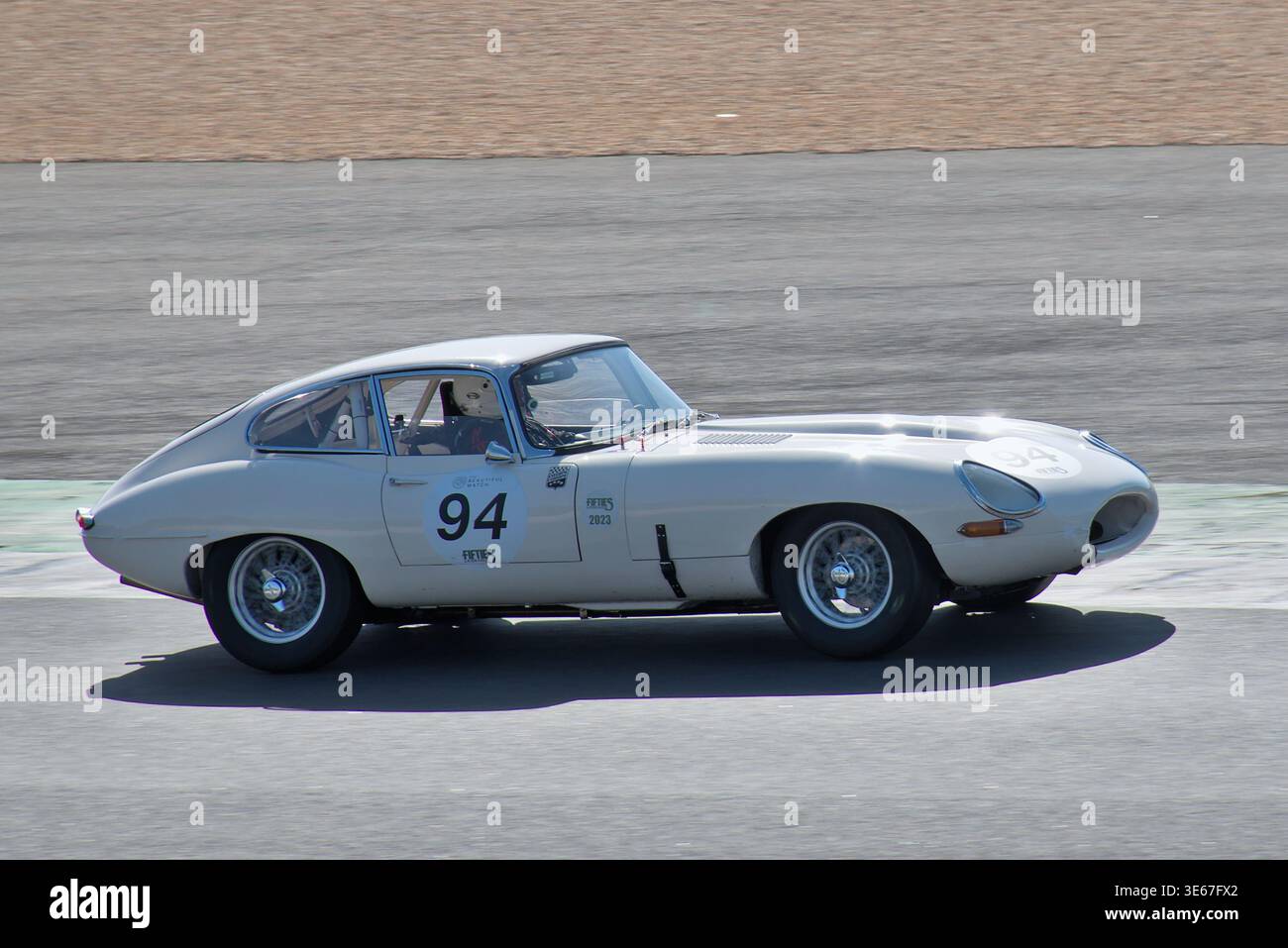 La Jaguar E-type 3,8 passe par le virage 1 à Estoril. L'élégance britannique intemporelle rencontre des performances brutes sur piste Banque D'Images
