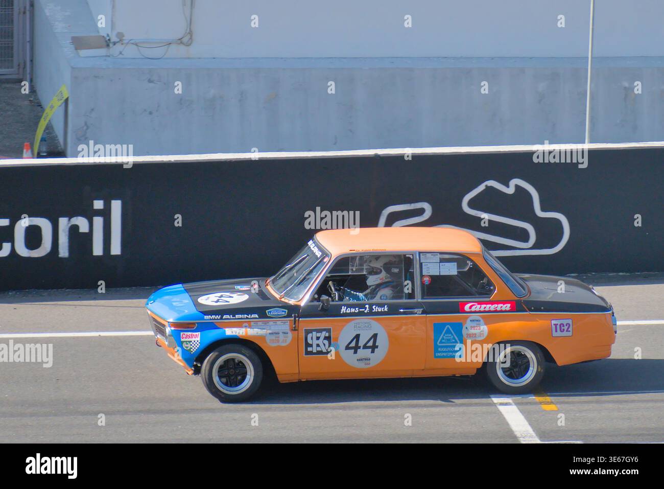 La BMW 323i 1984 en inclinaison maximale ! Katrin Behrens franchissant la ligne de départ-arrivée dans une exposition du patrimoine du Groupe A. Banque D'Images