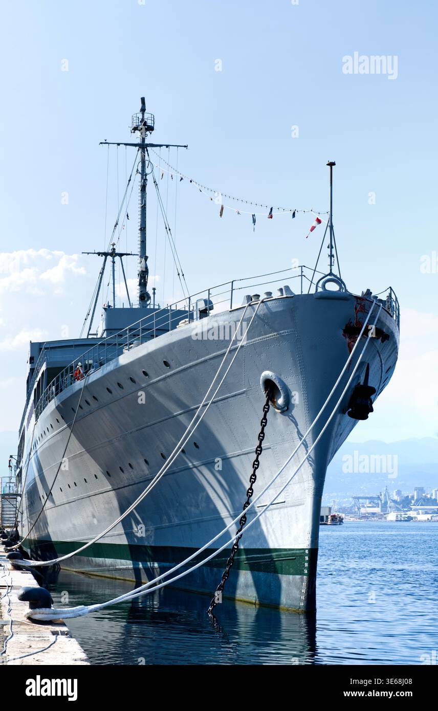 Une photographie détaillée en gros plan d'un grand navire amarré dans un port. L'image met en évidence l'arc, la chaîne d'ancre et les cordes d'amarrage épaisses, avec Wate calme Banque D'Images