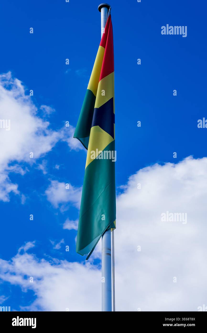 Gros plan du drapeau national du Ghana sur le mât de drapeau contre le ciel bleu avec des nuages. Vertical, espace copie, drapeau africain, afrique de l'Ouest. Banque D'Images