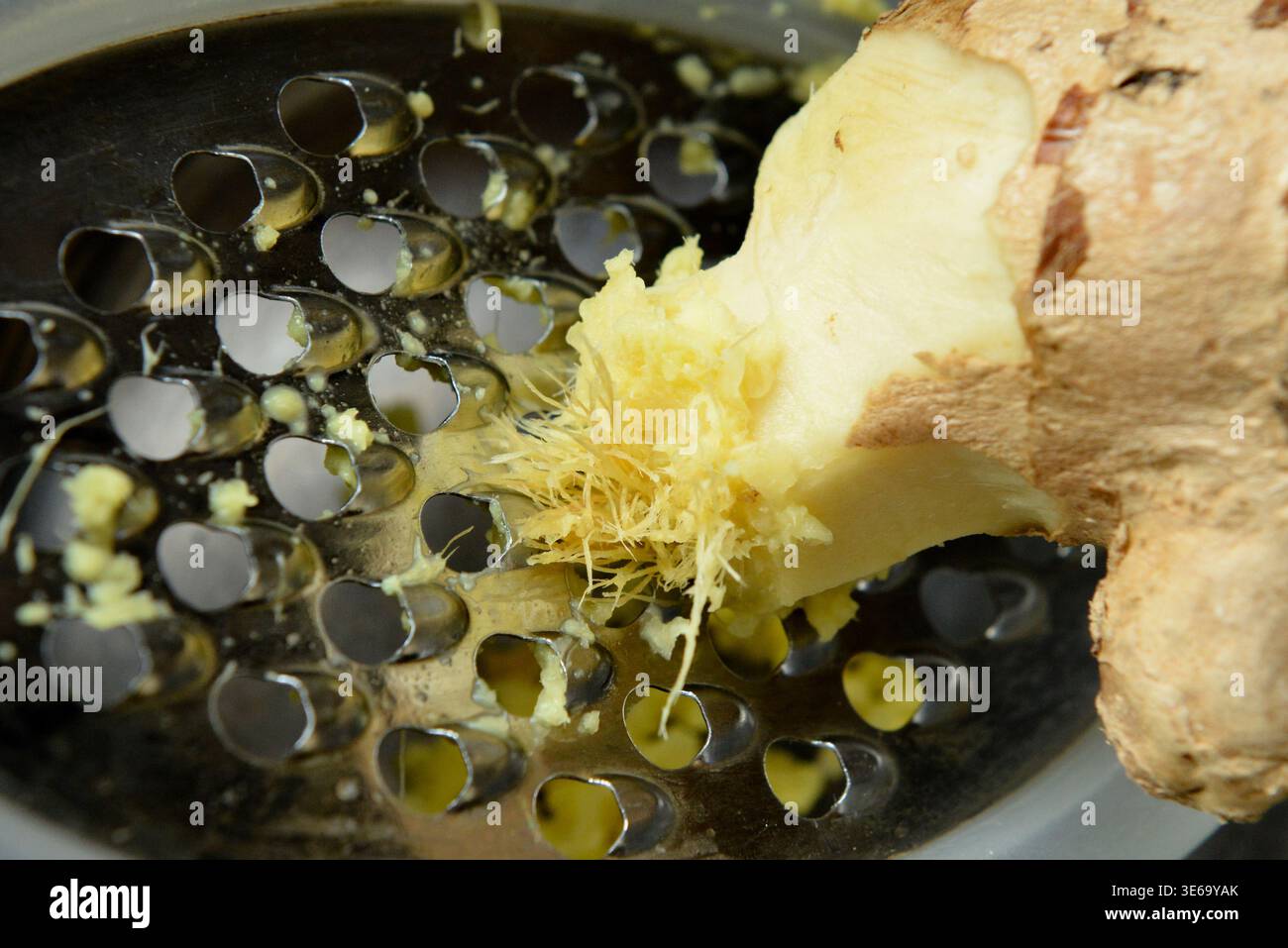 Racine de gingembre râpée avec un concept de râpe et de cuisine maison Banque D'Images
