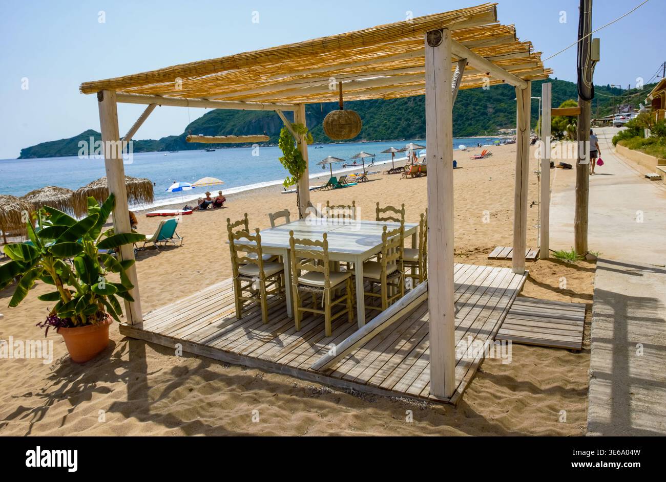 Restaurant de plage en plein air assis sous un auvent de roseau à la plage d'Agios Georgios. Paysage d'été de Corfou, Grèce, pris le 14 juillet 2023. Banque D'Images