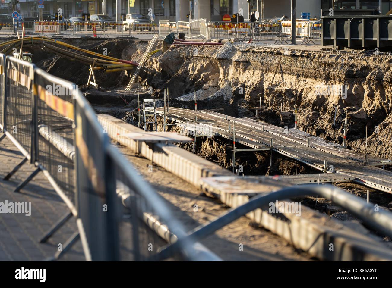 Grand projet d'infrastructure urbaine montrant l'excavation de routes publiques avec des clôtures métalliques de site et des plates-formes temporaires pour le génie civil et les tuyaux Banque D'Images